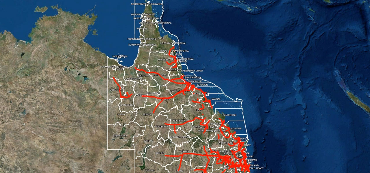 A detailed map of Queensland, Australia, showcasing geographic boundaries and waterways marked in red. 