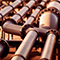 A closeup photo of rows of dull silver pipes reflecting orange sunset light